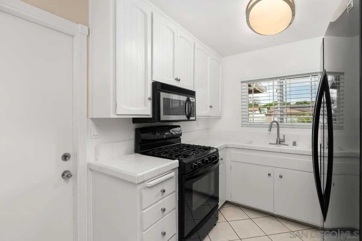 10025 Pinewood View Santee, CA 92071 - Photo 8 of 29 a kitchen with white cabinets and sink