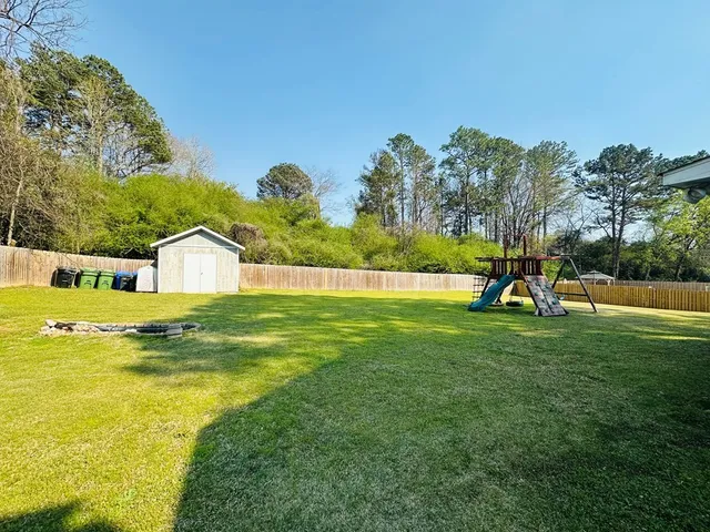 a house view with swimming pool and trees in the background