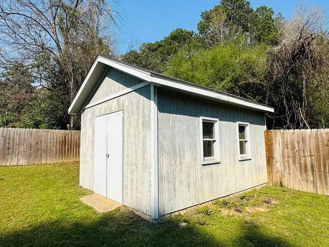 a view of backyard of house with wooden fence