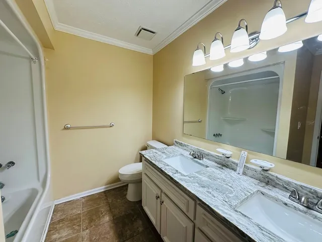 a bathroom with a granite countertop sink a toilet and a mirror