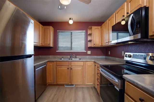 a kitchen with stainless steel appliances granite countertop a sink stove and microwave