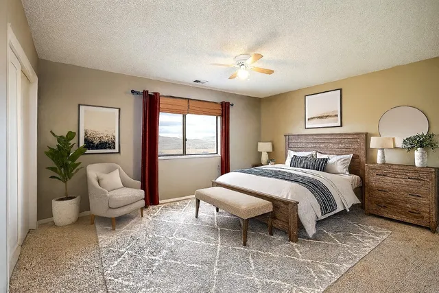 a spacious bedroom with a bed and ceiling fan