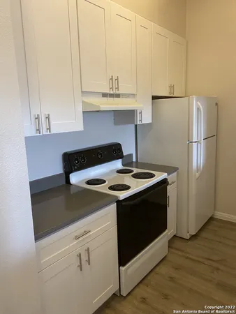 a kitchen with granite countertop a sink stove and refrigerator