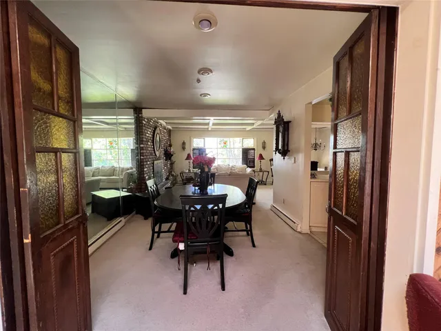 a dining room with furniture and a floor to ceiling window