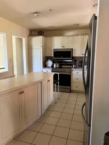 a kitchen with stainless steel appliances a refrigerator sink and cabinets