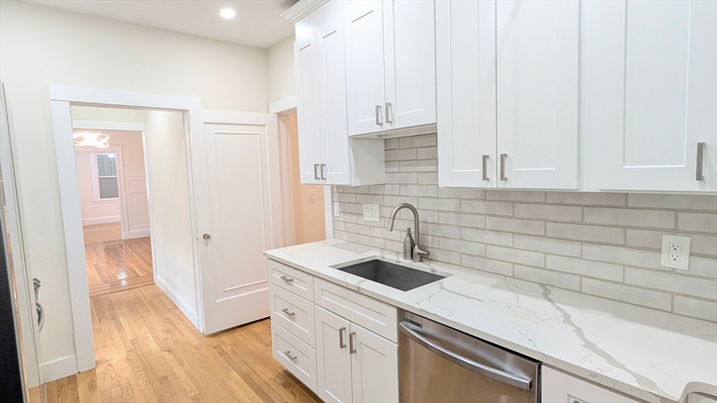 446 Lowell Avenue, Unit 446 Newton, MA 02460 - Photo 3 of 15 a kitchen with a sink and cabinets