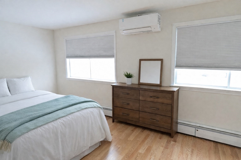 446 Lowell Avenue, Unit 446 Newton, MA 02460 - Photo 4 of 15 a bedroom with a bed and a dresser