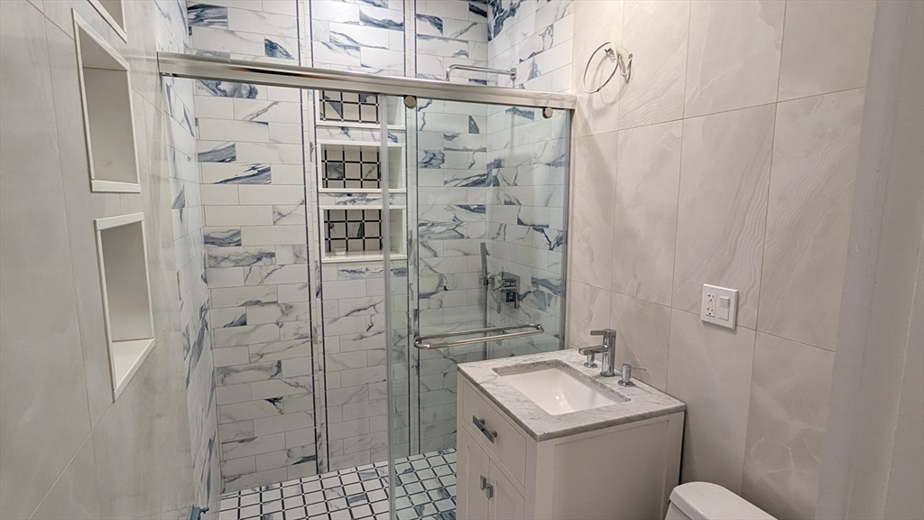 446 Lowell Avenue, Unit 446 Newton, MA 02460 - Photo 6 of 15 a bathroom with a sink toilet and shower