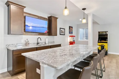 a living room with granite countertop furniture and a flat screen tv