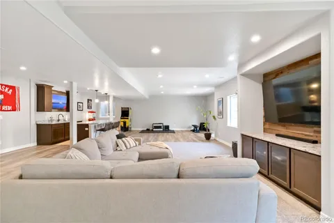 a living room with furniture kitchen view and a flat screen tv