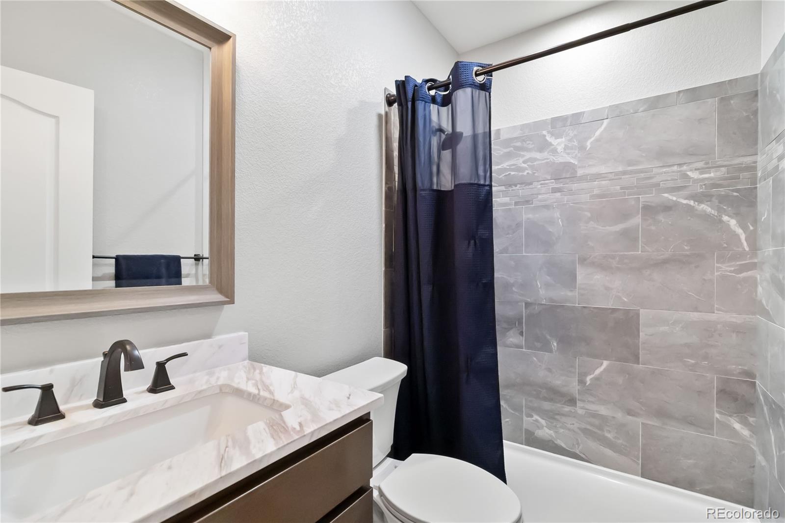 3034 Mashie Circle Castle Rock, CO 80109 - Photo 22 of 50 a bathroom with a granite countertop sink toilet and shower