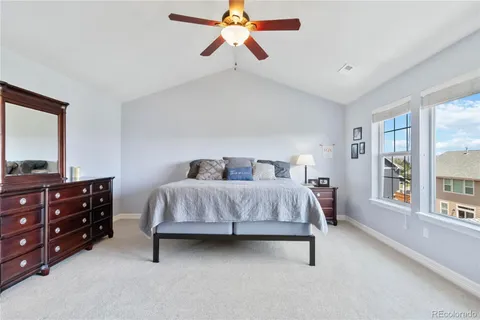 a bedroom with a bed a chandelier and a dresser