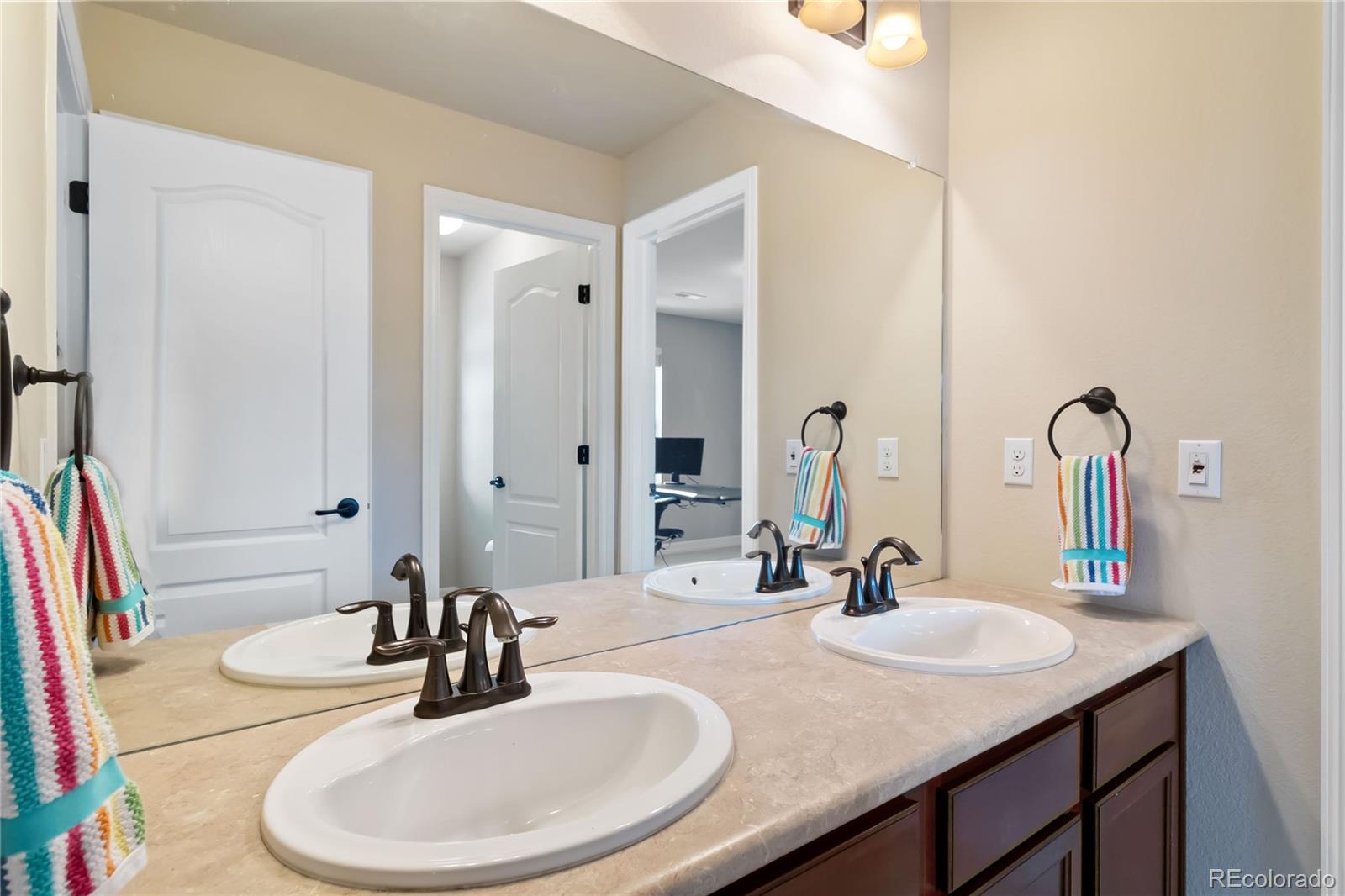 3034 Mashie Circle Castle Rock, CO 80109 - Photo 30 of 50 a bathroom with a granite countertop sink and a mirror