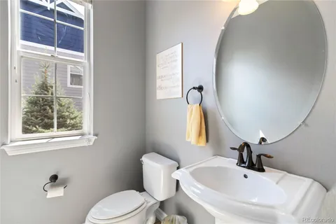 a bathroom with a sink vanity mirror and toilet