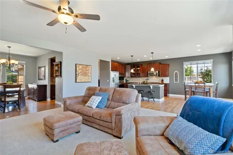a living room with furniture kitchen view and a large window