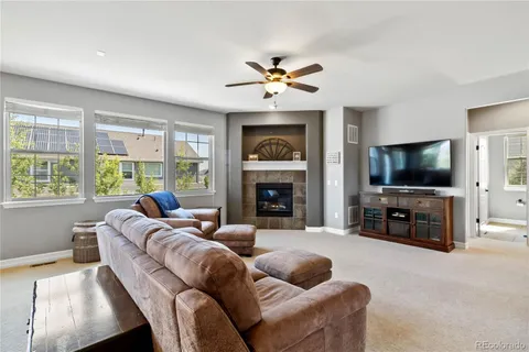 a living room with furniture a flat screen tv and a fireplace
