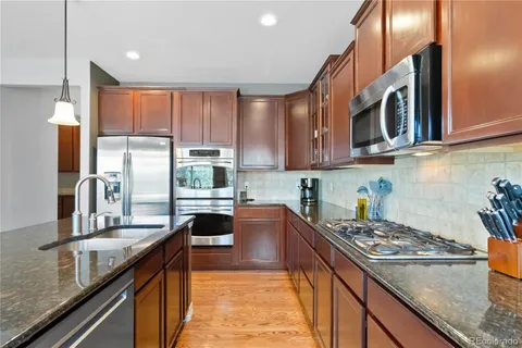 a kitchen with stainless steel appliances granite countertop a stove a sink and a refrigerator