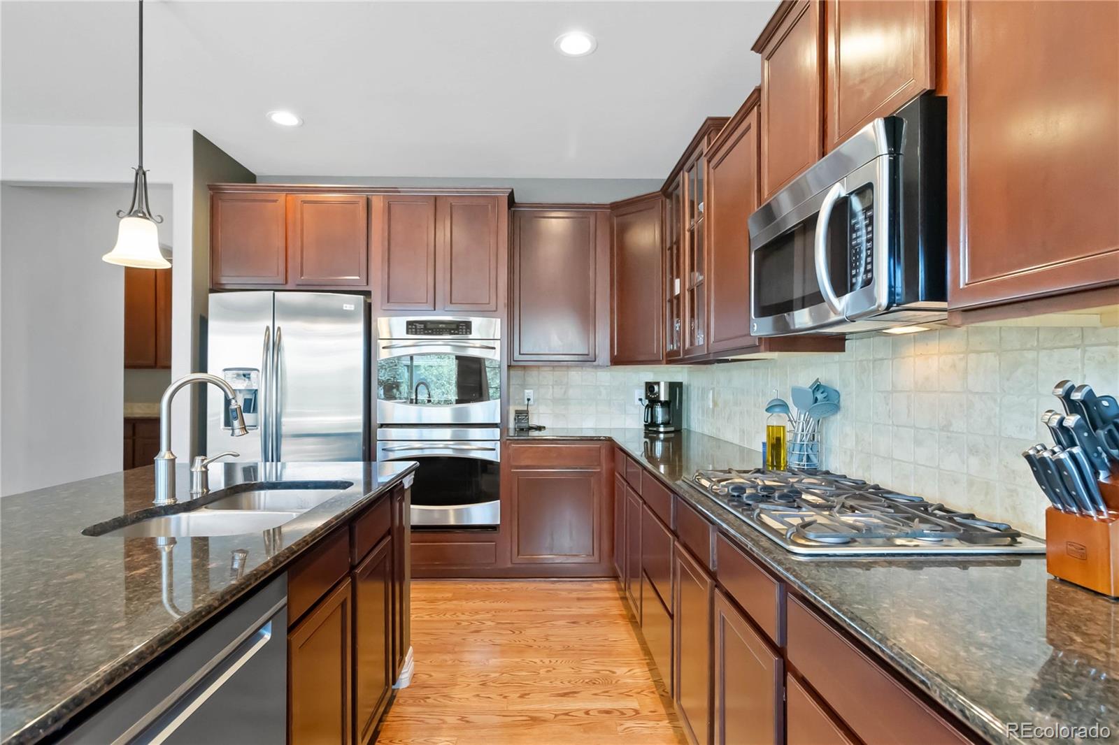 3034 Mashie Circle Castle Rock, CO 80109 - Photo 9 of 50 a kitchen with stainless steel appliances granite countertop a stove a sink and a refrigerator
