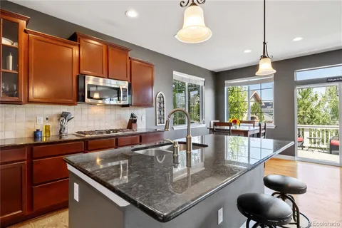 a kitchen with stainless steel appliances granite countertop a stove a sink a microwave dining table and chairs