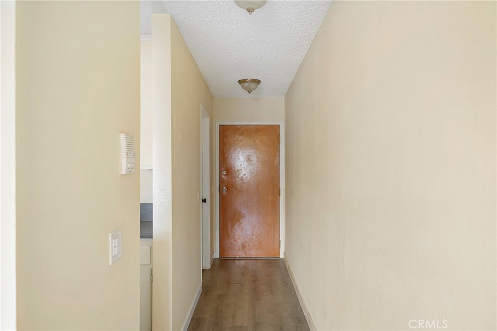16226 Vanowen Street, Unit 207 Van Nuys, CA 91406 - Photo 3 of 17 a view of a hallway with wooden floor