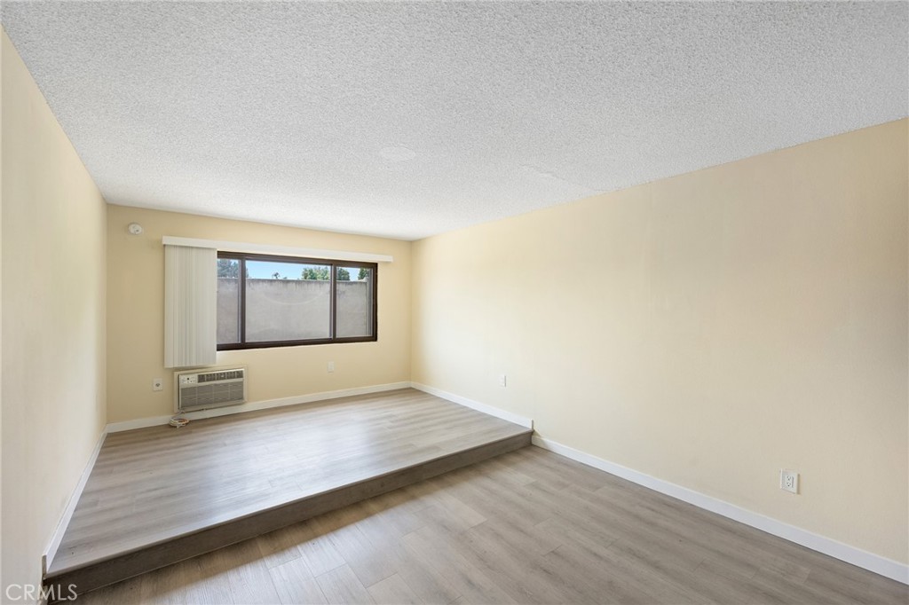 16226 Vanowen Street, Unit 207 Van Nuys, CA 91406 - Photo 4 of 17 an empty room with wooden floor and windows