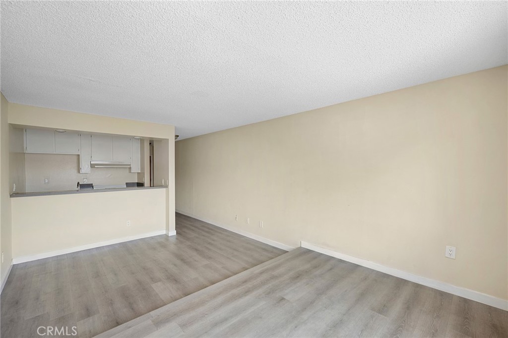 16226 Vanowen Street, Unit 207 Van Nuys, CA 91406 - Photo 6 of 17 a view of a room with wooden floor and a sink