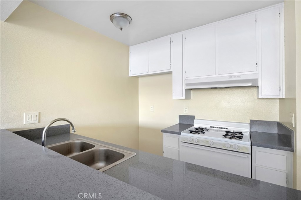 16226 Vanowen Street, Unit 207 Van Nuys, CA 91406 - Photo 9 of 17 a kitchen with a sink and cabinets