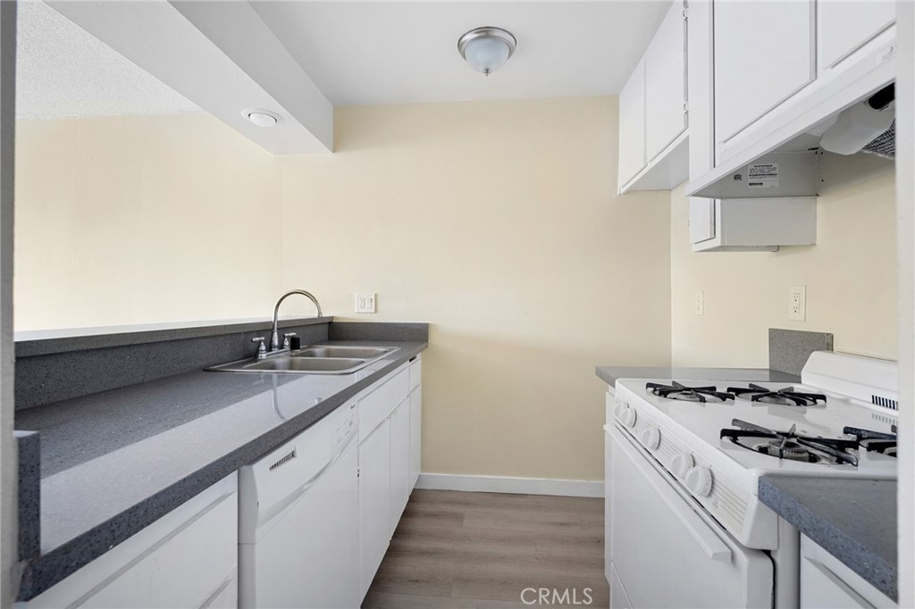 16226 Vanowen Street, Unit 207 Van Nuys, CA 91406 - Photo 10 of 17 a kitchen with a sink stove and cabinets
