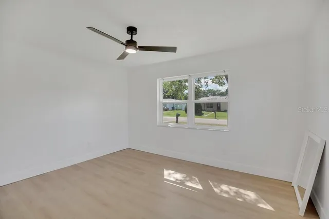 a view of wooden floor and a window in a room