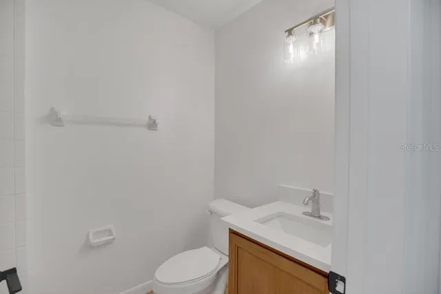a bathroom with a granite countertop toilet and sink