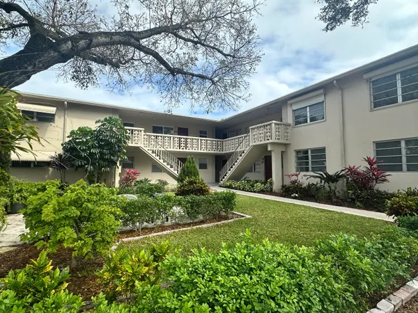 a front view of a house with a yard and potted plants
