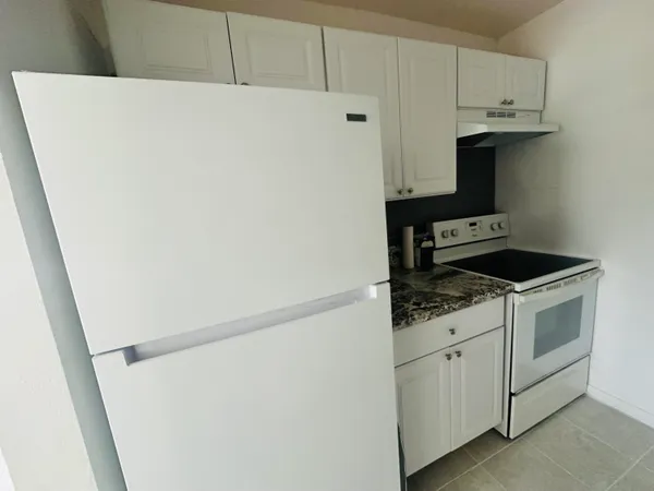 a kitchen with white cabinets and white appliances