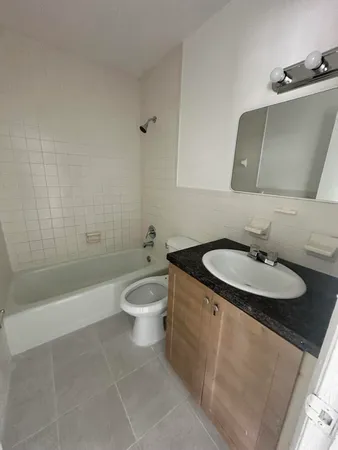 a bathroom with a granite countertop sink a toilet and bathtub