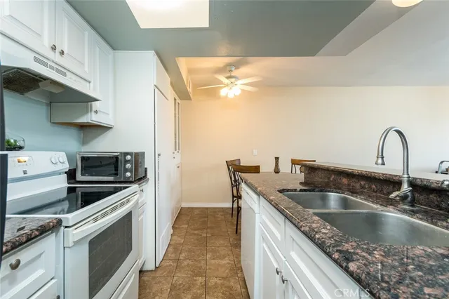 a kitchen with granite countertop a sink and a stove top oven
