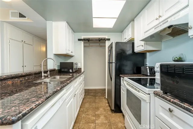 a kitchen with stainless steel appliances granite countertop a sink a stove and a refrigerator
