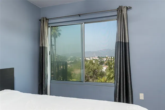 a bedroom with a bed and a dresser next to a window