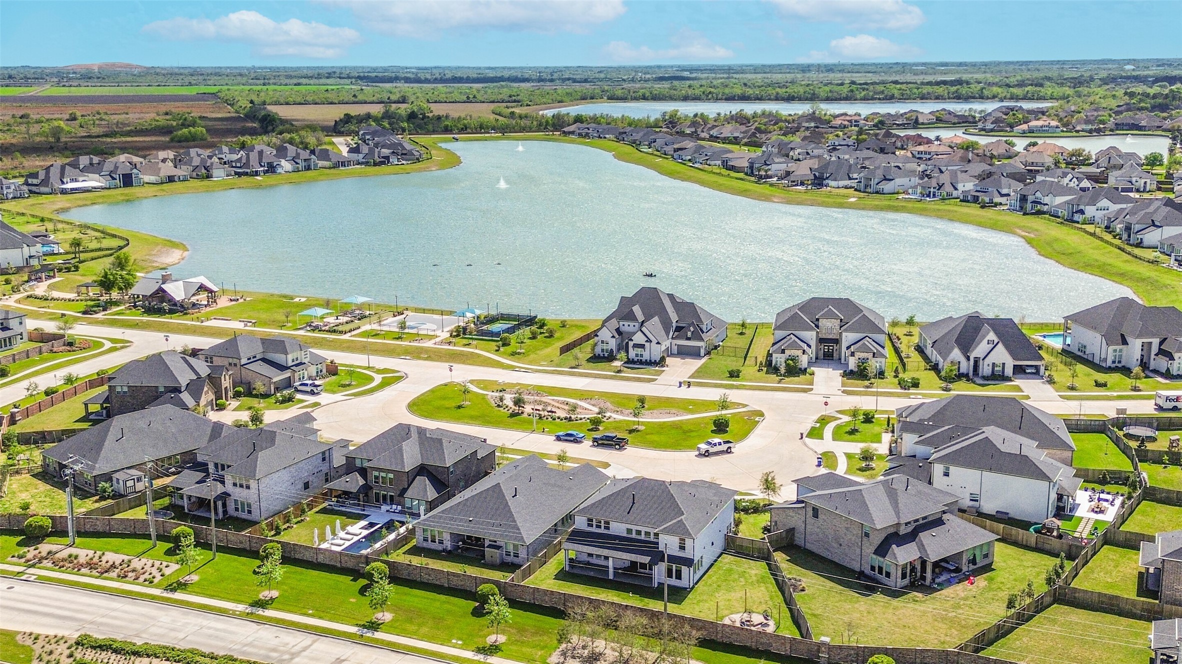 1612 Dayton Rdg Circle Friendswood, TX 77546 - Photo 2 of 50 modern homes surrounding a large, serene lake. The area features well-maintained streets, green lawns, and offers a peaceful, spacious environment perfect for family living.