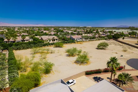 an aerial view of ocean and residential houses with outdoor space