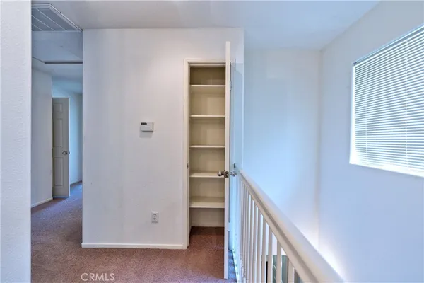 a view of a hallway with bathroom and glass door