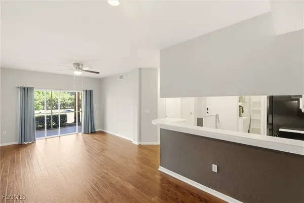 a kitchen with a refrigerator and white cabinets