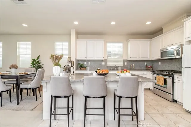 a kitchen with granite countertop white cabinets stainless steel appliances and a sink