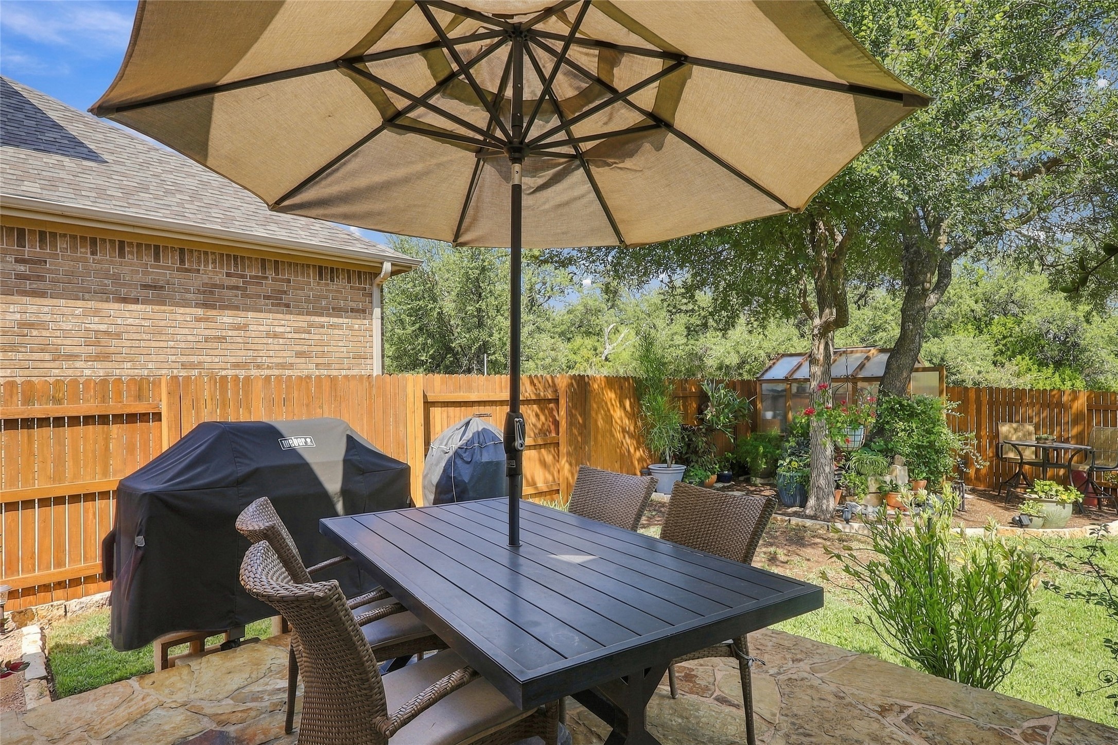 320 Fort Cobb Way Georgetown, TX 78628 - Photo 28 of 37 A spacious stone patio overlooks the fully fenced yard complete with mature shade trees.