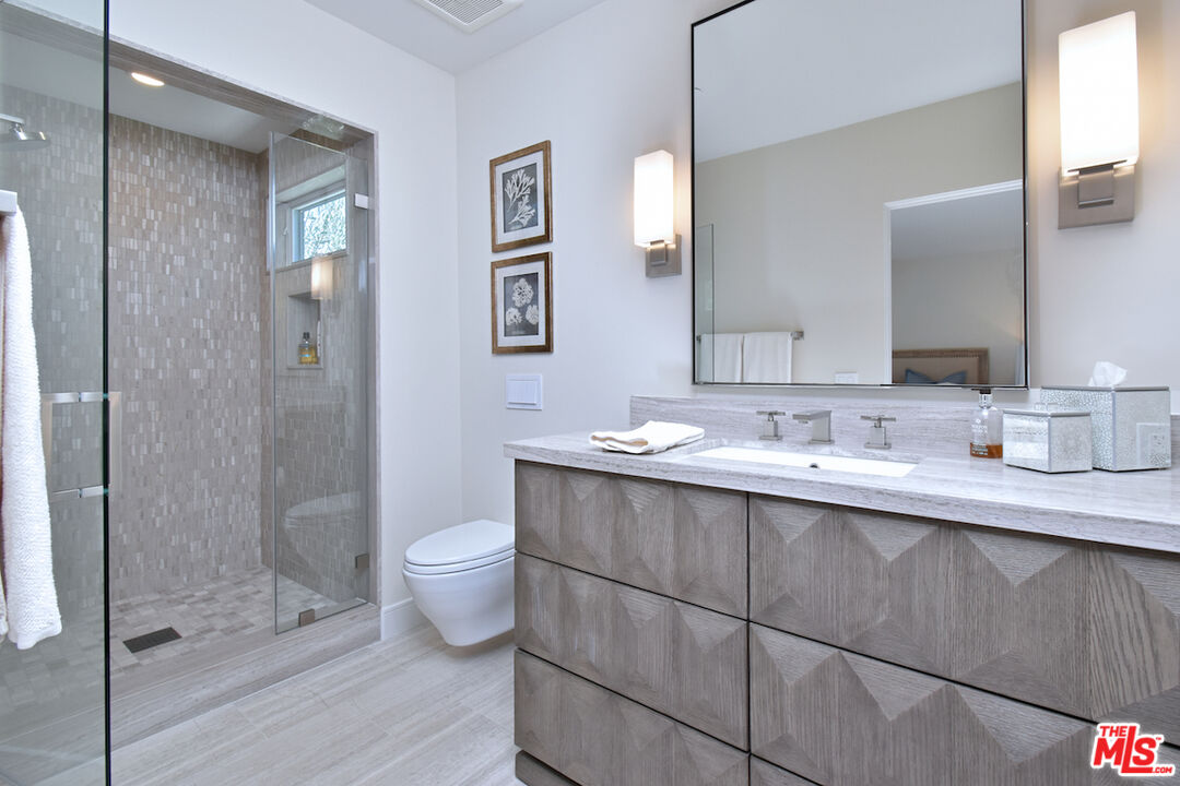 922 Berkeley Street Santa Monica, CA 90403 - Photo 13 of 33 a bathroom with a double vanity sink toilet and shower