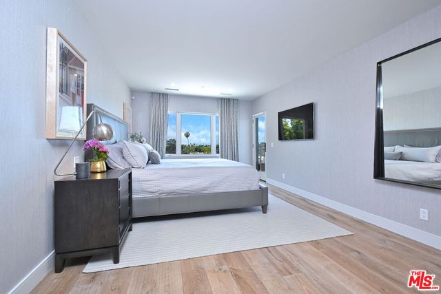 a bedroom with a bed and a flat screen tv