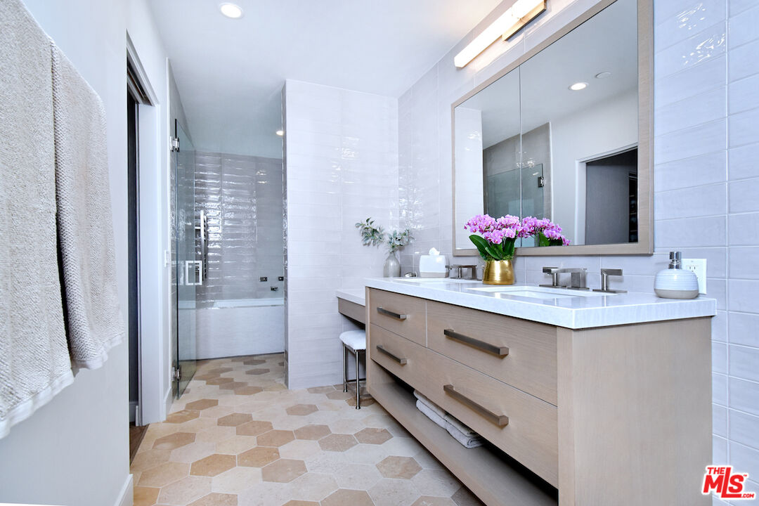 922 Berkeley Street Santa Monica, CA 90403 - Photo 17 of 33 a bathroom with a sink vanity granite tub shower and a mirror