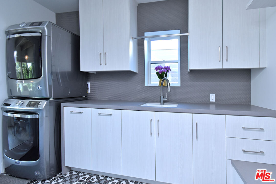 922 Berkeley Street Santa Monica, CA 90403 - Photo 24 of 33 a kitchen with stainless steel appliances white cabinets and a sink