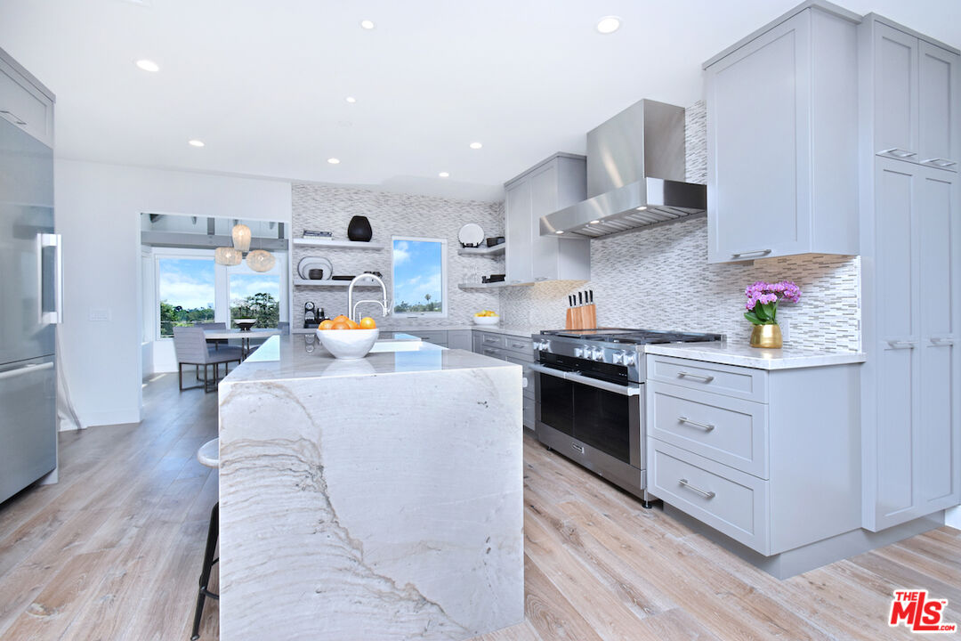 922 Berkeley Street Santa Monica, CA 90403 - Photo 9 of 33 a kitchen with stainless steel appliances granite countertop a sink a stove and a wooden floors