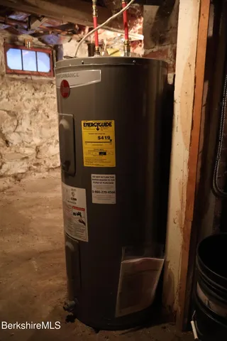 a room with water heater and wooden walls