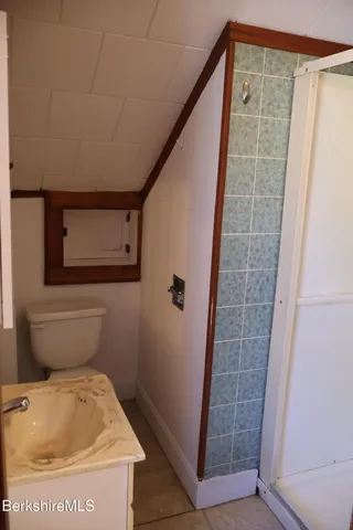 a bathroom with a toilet and a shower