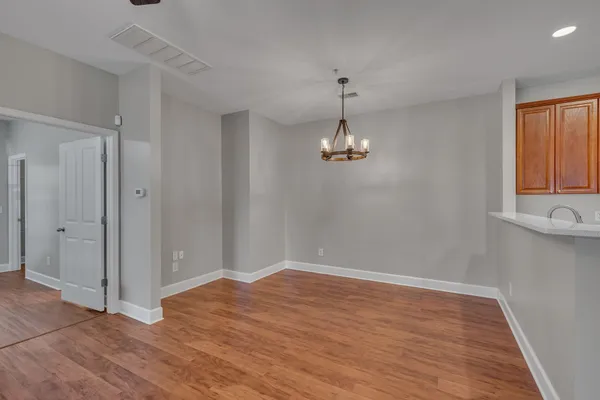 a view of empty room with wooden floor and window